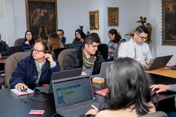 Participantes trabajando en un reporte durante la capacitación